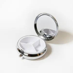 Vue détaillée d'un pilulier rond en métal avec 3 compartiments et un miroir intérieur