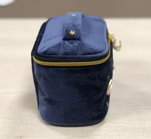 Dunkelblaue Samt-Kosmetiktasche mit Goldstern-Stickerei und Tragegriff für Reisen.
