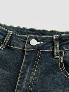 Detail of high-waisted flared denim jeans with washed finish and contrast stitching
