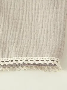 Close-up of delicate white heart-shaped lace trim on premium beige crinkled gauze fabric
