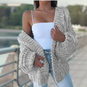 Close-up detail of grey chunky cable-knit cardigan with a textured oversized fit