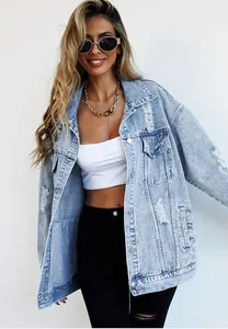 Detail view of a distressed light blue denim jacket featuring a trendy ripped design