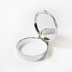 Vue détaillée d'une boîte à pilules ronde en métal argenté ouverte avec miroir intérieur