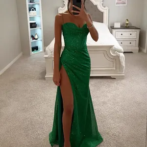 Robe longue élégante à paillettes vert émeraude avec fente haute et fines bretelles.