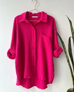 Macro view of hot pink crinkle fabric texture on casual long-sleeve button-down shirt.