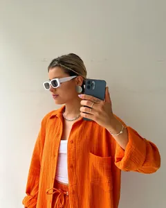 Detailed view of the orange textured fabric on a two-piece fashion shirt and shorts set.