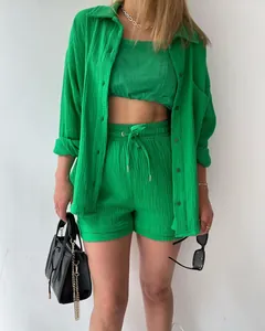 Detailed view of women's green crinkle fabric outfit with long sleeve shirt and shorts.