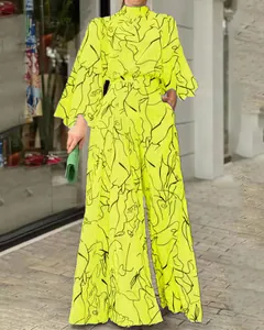 Elegante tuta giallo neon a gamba larga con stampa astratta viso e maniche lunghe
