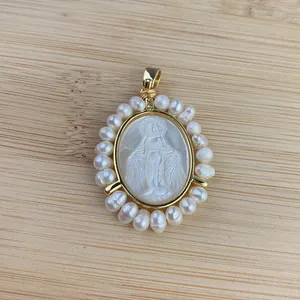 Détail du pendentif Vierge Marie en nacre entouré de perles d'eau douce fines.
