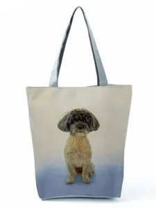 Detail view of the lifelike cute poodle dog print on a grey and white canvas tote bag.