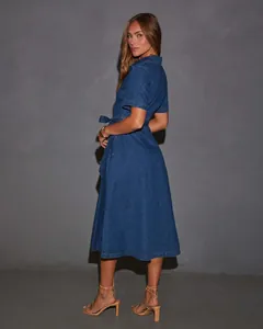 Vista laterale di un vestito di jeans a maniche corte con scollo a V e cintura per donna.