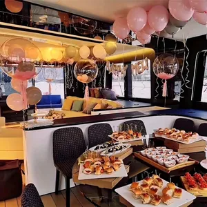 Pailles en plastique roses et rouges en forme de cœur dans un décor de fête sur un bateau