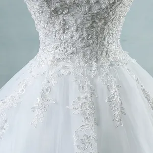 Close-up detail of white French wedding dress with lace embroidery and pearl beads