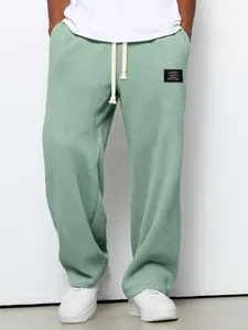 Model trägt salbeigrüne Waffelstrick-Jogginghose mit weitem Bein und Kordelzug für Herren