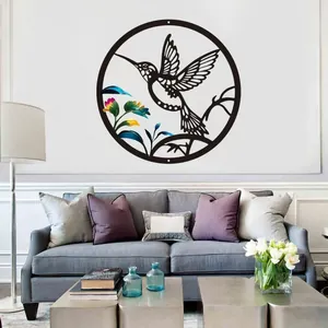 Black laser-cut metal hummingbird wall art decor displayed above a modern living room sofa