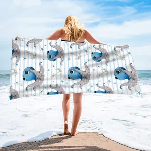 Back view of model holding a microfiber beach towel with octopus print on beach