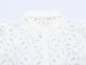 Detailed close-up view of the intricate floral water-soluble lace embroidery on white shirt collar.