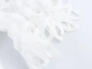 Detailed macro shot of intricate white water-soluble lace embroidery on a shirt