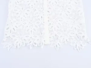 Detailed macro shot of white water-soluble floral embroidery lace on a French style shirt
