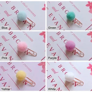Detailed view of colorful decorative pom-pom paper clips in six vibrant colors