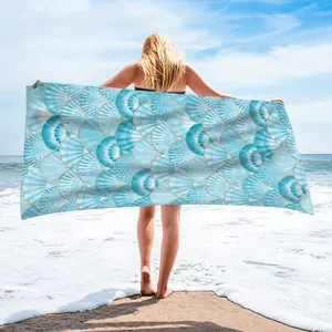 Large microfiber beach towel featuring a blue and white seashell pattern with gold accents