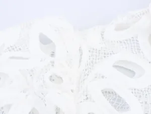 Macro view of delicate white water-soluble embroidery lace texture on French style shirt