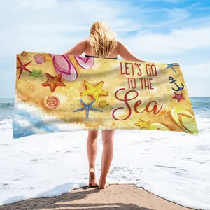 Microfiber beach towel with 'Let's Go to the Sea' sea-themed print used at the beach.