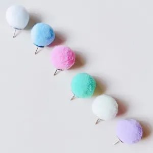 Close-up of colorful pom-pom push pins for creative cork board decoration