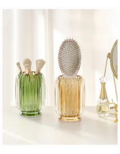 Macro view of ribbed glass makeup brush and comb holder on a stylish vanity table