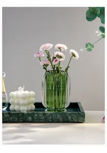 Close-up detail of green fluted glass makeup brush holder used as an elegant flower vase
