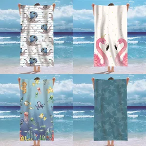 Detailed view of four colorful microfiber beach towels with ocean-themed patterns on beach.