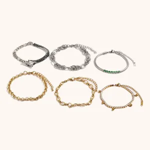 Detailweergave van zes minimalistische roestvrijstalen goud- en verzilverde kettingarmbanden