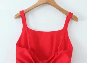 Detailed close-up of a red mini dress featuring a square neck and large back bow