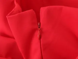 Detailed macro view of the seamless red invisible zipper on a chic mini dress
