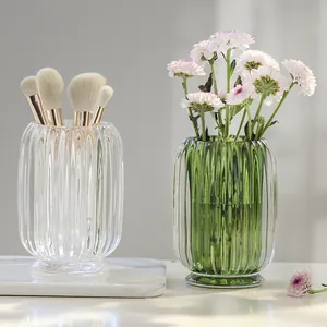 Elegant ribbed glass makeup brush holder and decorative vase in Nordic luxury style.