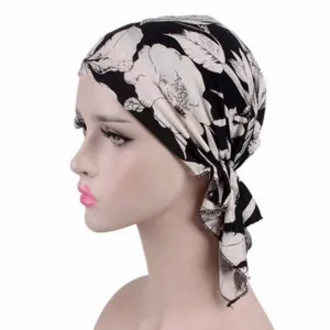 Side view detail of a stylish black and white floral printed turban headscarf for women