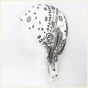 Detailed macro view of white cotton bandana headscarf with black paisley print pattern