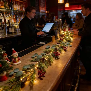 Nahaufnahme einer festlichen Weihnachtsgirlande mit Beeren und LED-Lichtern auf einer Bar