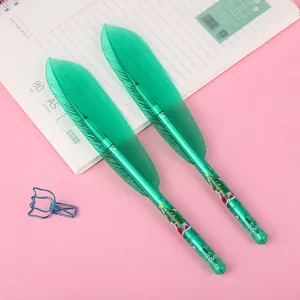 Macro view of creative green feather-shaped gel pens with Christmas tree decorations.