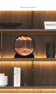 Circular moving sand art decor with orange sand layers on a bookshelf in a study