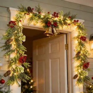 Detailansicht einer künstlichen Weihnachtsgirlande mit warmen LEDs und roten Beeren
