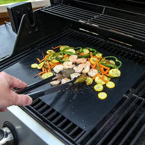 Heat-resistant non-stick Teflon BBQ grill mat shown with shrimp and vegetables on a grill