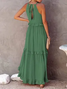 Back view of a sage green summer maxi dress with ruffle detailing and tie-back