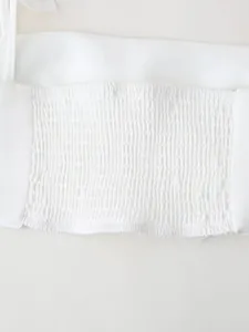 Detailed macro view of the elastic smocked back texture on this white solid crop top