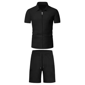 Completo estivo da uomo in due pezzi con polo nera a maniche corte con zip e pantaloncini.