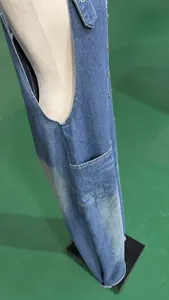 Side view detail of vintage washed loose denim overalls with pockets on a mannequin