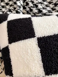 Detailed macro shot showcasing the plush black and white checkerboard pillow texture