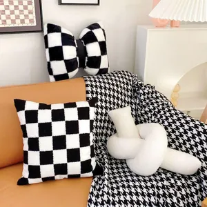 Detail view of black and white checkered plush cushions on a modern sofa