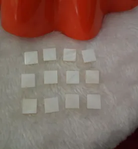 Detailed view of square white iridescent shell pieces for DIY jewelry and hair accessories.