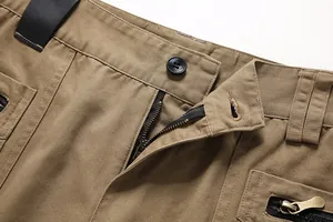Detailed macro shot of men's durable cotton cargo pants zipper fly and pocket stitching